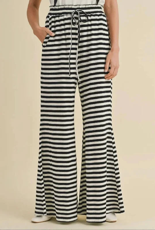 Wide-leg trousers – Trousers with a loose, flared fit from the hips down to the ankles.Calliope Bottoms In Black/white